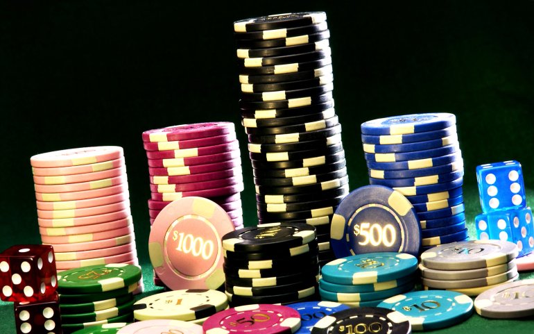 Un sacco di fiches da gioco da 1000 e 500 dollari e dadi.