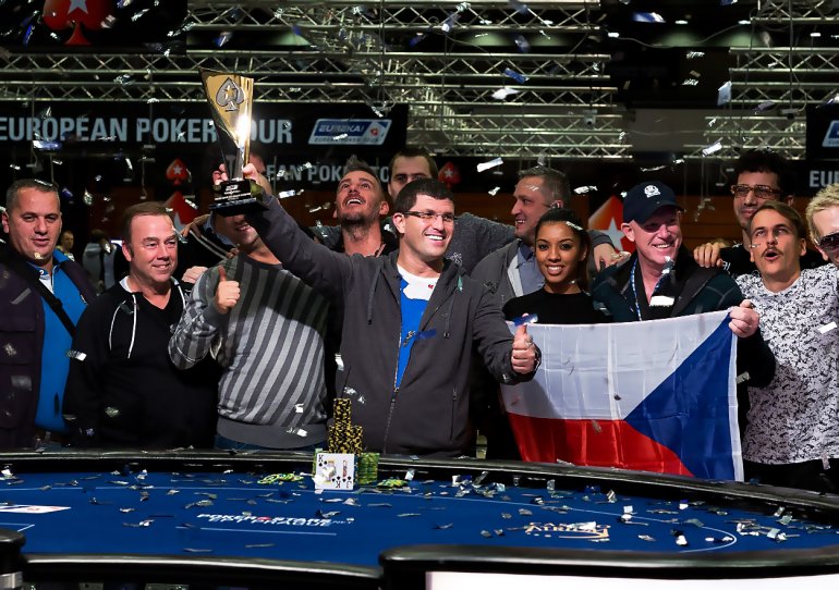 Giocatore maschio con una coppa del vincitore del torneo vinta e una vincita di fiches importante